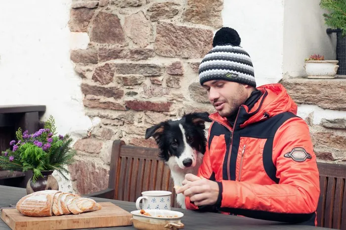 Černá pánská zimní pletená čepice s bambulí a barevnými pruhy